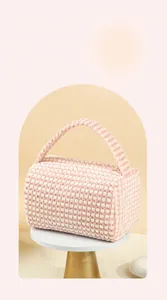 Detail of checkered plush cosmetic bag featuring a wide opening and soft woven texture