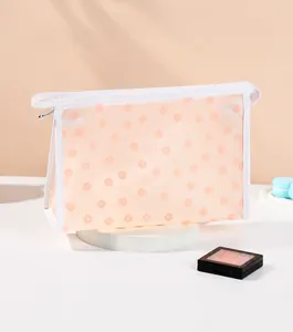 Detail view of mesh makeup bag with orange floral print and white zipper closure