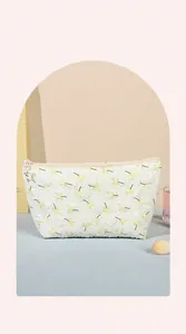 Detalle del neceser acolchado blanco con flores y tirador de cremallera de estrella