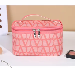 Detail of coral pink makeup bag featuring V-pattern texture and metal dual zippers
