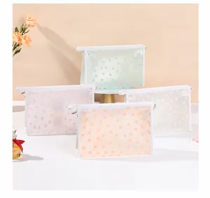 Détail de quatre trousses de toilette en maille avec motifs floraux et fermetures éclair