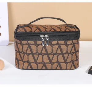 Detail view of the durable canvas makeup bag featuring a geometric V pattern and leather handle