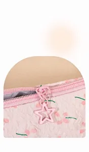 Detalle del neceser floral rosa con tirador de estrella y cremallera metálica deslizante