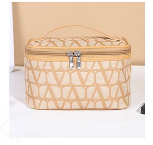 Detail of beige V-pattern toiletry bag with double zipper and top handle for travel