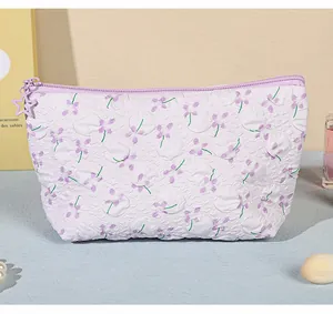 Dettaglio della borsa per il trucco floreale con stampa viola e cerniera a stella