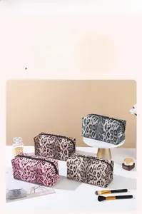 Detailed close-up of leopard print makeup bags in pink, brown, grey, and tan colors