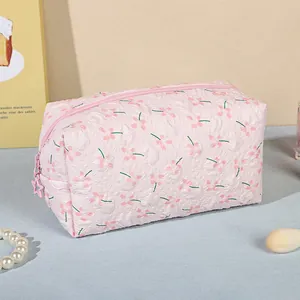 Pink quilted makeup bag with floral patterns and star zipper head, rectangular shape