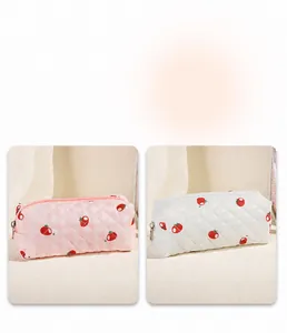 Detail of floral quilted makeup bags with orange fruit pattern and silver zippers