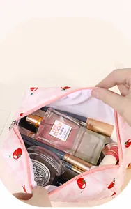 Detail of floral strawberry quilted makeup bag showing large capacity with various cosmetics