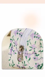 Detail of smooth metal zipper and quilted floral fabric on portable cosmetic bag
