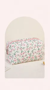 Detailed close-up showing the large opening and floral quilted fabric of the travel cosmetic bag