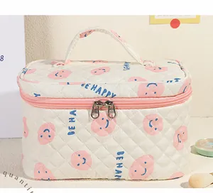 Dettaglio della borsa cosmetica trapuntata con cerniere rosa e stampa Be Happy colorata