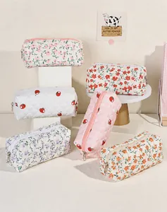 Detailed view of quilted cotton makeup bags with various floral and strawberry patterns