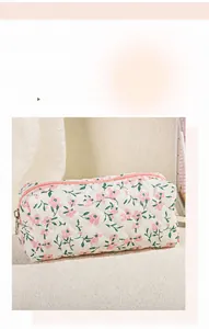 Detailed macro view of quilted floral cosmetic bag with pink zipper and stitch texture