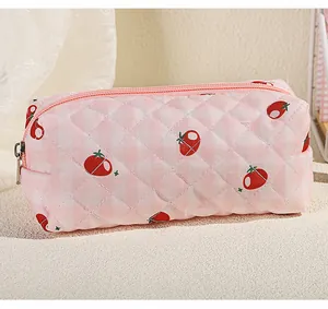 Close-up of quilted strawberry floral wash bag with pink zip and rhombic texture