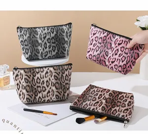 Detail shot of leopard print makeup bags in gray, pink, and brown with zipper closure