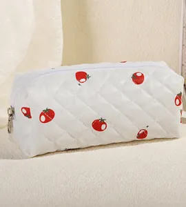 Detail of strawberry print on white quilted fabric with a sleek zipper closure