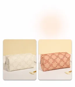 Detail view of square PU makeup bags in milky white and rose pink with floral patterns