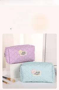 Close-up of quilted wave pattern makeup bags in lilac and light blue colors