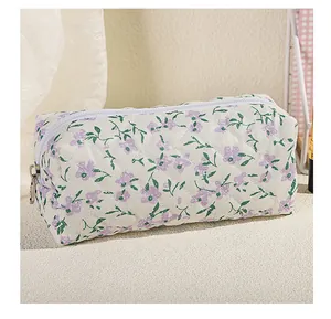 Close-up of quilted floral cosmetic bag with purple flowers and silver zipper detail
