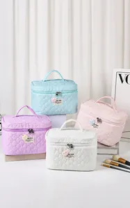 Detalle del bolso de maquillaje grande en tonos pastel con textura de burbujas y asa