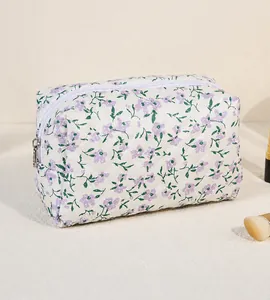 Detail of quilted floral makeup bag with purple flowers and silver zipper closure