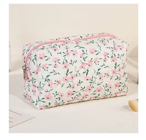 Detail of floral quilted makeup bag showing pink zipper and soft textured fabric