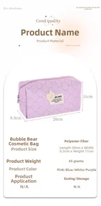 Macro detail of purple quilted cosmetic bag with bear label showing dimensions 20x8.5x11cm