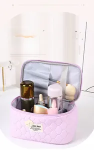 Detail view of purple quilted bear makeup bag featuring brush slots and elastic organizers