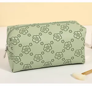 Detailed side view of light green floral PU makeup bag with silver metal zipper closure