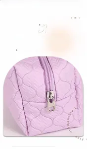 Detail of lavender quilted makeup bag showing smooth silver zipper and stitching