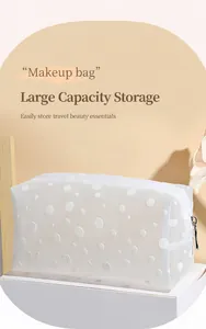 Détail de la trousse de maquillage transparente à pois avec fermeture éclair argentée