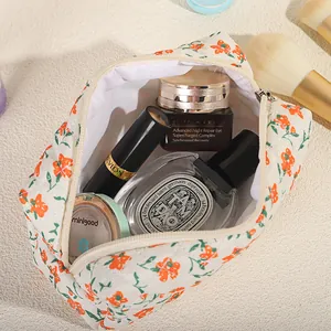 Quilted floral makeup bag with orange flowers and top zipper for travel storage