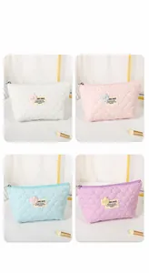 Quilted heart pattern cosmetic bags in white, pink, blue and purple with teddy bear label