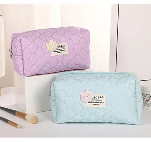 Close-up of quilted wave texture on lavender and blue cosmetic bags with bear patches