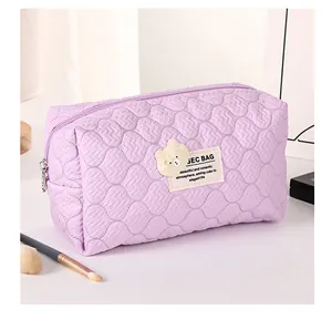 Close-up of purple quilted wavy texture on cosmetic bag with cute bear patch detail