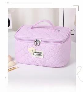 Detail of lavender quilted fabric cosmetic bag with double metal zippers and top handle