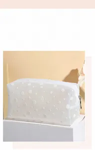 Détail de la trousse de maquillage en filet à pois blancs avec fermeture éclair