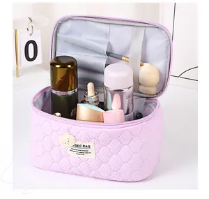Detailed interior of quilted bear cosmetic bag showing brush slots and large storage