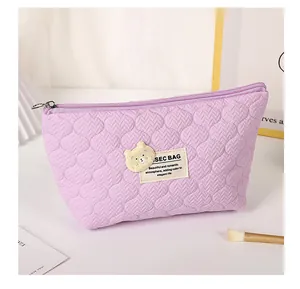 Detail of purple quilted bear cosmetic bag with metal zipper and soft texture fabric