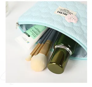 Detail of light blue quilted makeup bag showing spacious interior with cosmetic accessories