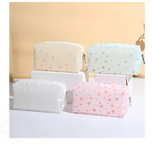 Vue détaillée des trousses cosmétiques semi-transparentes à pois de couleurs variées