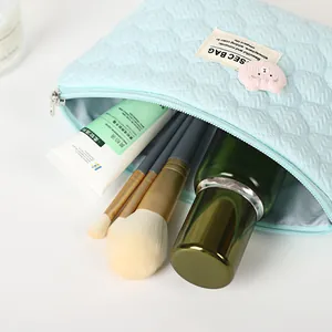 Light blue quilted cosmetic bag with heart texture and cute bear charm decor