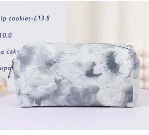 Macro detail of heart-shaped quilting and tie-dye fabric on the travel cosmetic bag