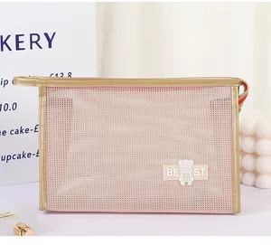 Detail of pink mesh makeup bag with bear motif and gold trim in a stylish setting