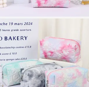 Close-up of heart-quilted cosmetic bags in pastel colors with high-capacity zipper design