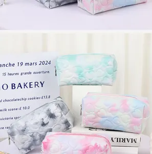 Detail view of heart-quilted toiletry bags in blue pink gradients and soft textures