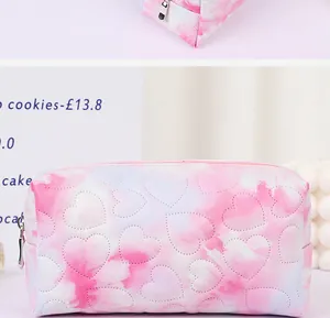 Detailed close-up of pink and white heart-quilted toiletry bag with silver zipper