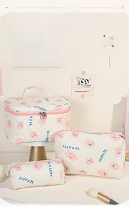 Lot de trois trousses à cosmétiques matelassées crème avec motif smiley et poignée