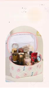 Vue détaillée de la trousse de maquillage blanche matelassée avec motif sourire et poches